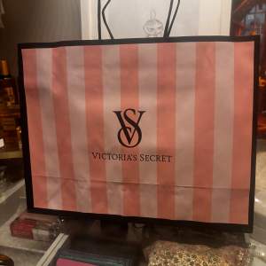 Säljer en snygg shoppingväska från Victoria's Secret i rosa och vit randigt mönster. Perfekt för en shoppingrunda eller som en stilren presentpåse. Väskan har två handtag och är i mycket bra skick. Passar perfekt för vår och sommar!