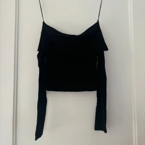 Svart offshoulder topp - Snygg svart offshoulder topp med långa ärmar. Perfekt för en utekväll eller fest. Den har en stilren design som passar till det mesta. Toppen är i bra skick och redo för nya äventyr!