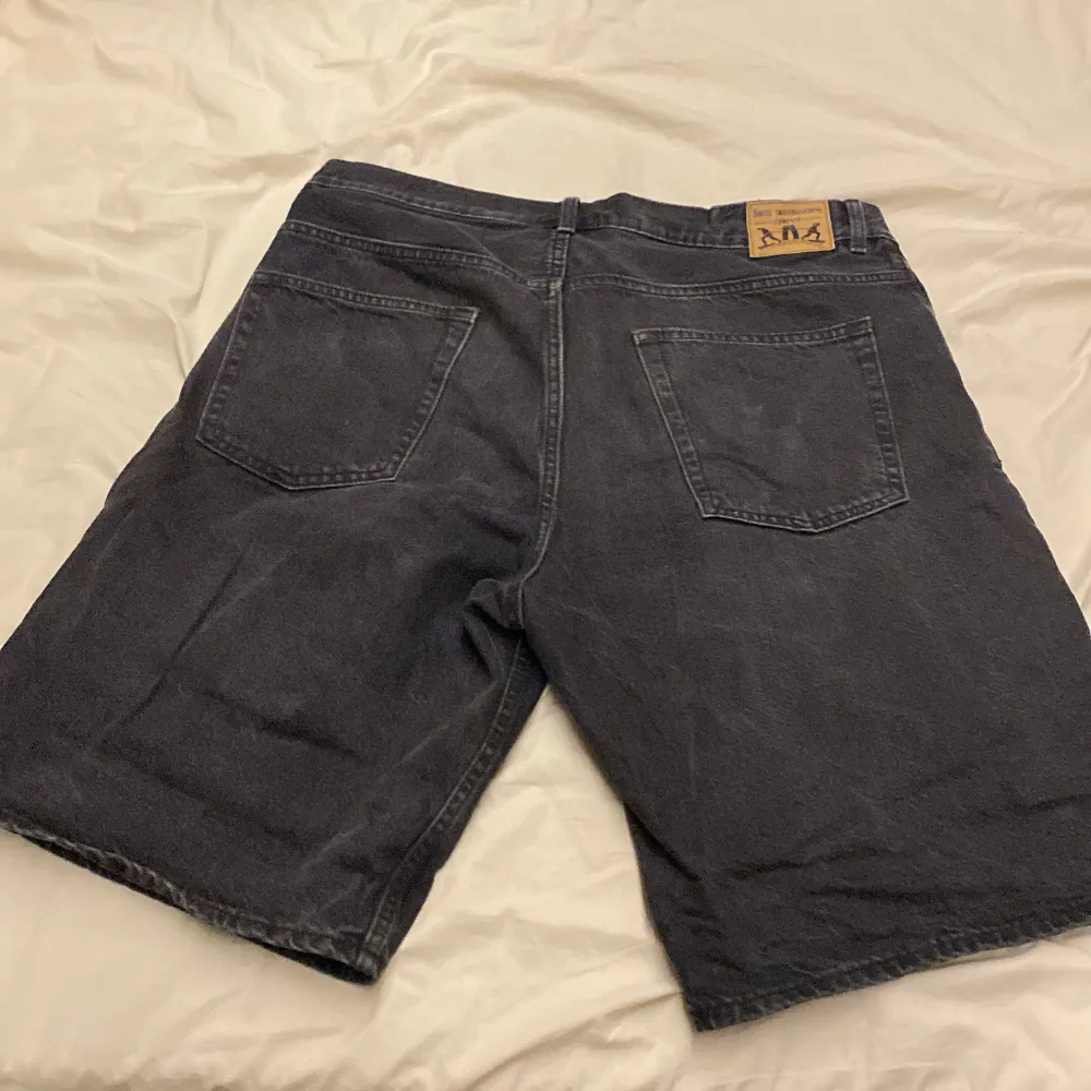 Säljer ett par svarta jeansshorts från Sweet SkTbs i storlek L. De har en klassisk femficksdesign med knapp och dragkedja framtill. Perfekta för en avslappnad stil under sommaren. Shortsens material är slitstarkt och bekvämt, vilket gör dem idealiska för vardagsbruk.. Shorts.