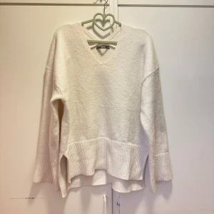 Vit stickad tröja - Säljer en vit stickad tröja från bikbok som inte kommer till användning. Man kan se lite på den att den är använd då den har börjat noppra sig lite på några ställen. Den är lite oversized i modellen