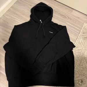 Svart hoodie från hm - Säljer en svart hoodie från hm i storlek XL. Den är supermjuk och varm med fleecefoder på insidan, perfekt för kyliga dagar. Hoodien har en klassisk design med dragsko i huvan och ribbade muddar vid ärmslut och nederkant. Perfekt för en avslappnad stil!