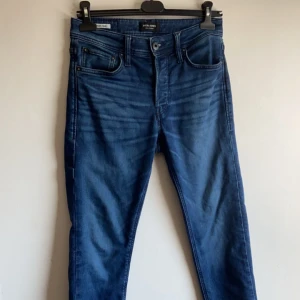 Jack and Jones jeans  - Säljer ett par snygga blå jeansbyxor i bra skick. De har en klassisk femficksdesign med dragkedja och knapp framtill. Perfekta för både vardag och fest! Passar till allt och är superbekväma. Modell comfort Mike i storlek 29/30