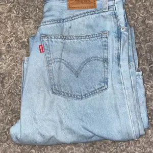 Säljer ett par klassiska ljusblå Levi's jeans i bra skick i high loose. De har den ikoniska läderpatchen och den röda Levi's-taggen på bakfickan. Perfekta för en avslappnad vardagslook. Passar till allt. Högmidjade, vida och raka i modellen.