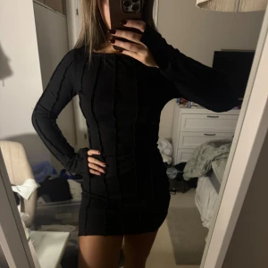 Svart tight klänning - Säljer en snygg svart tight klänning med långa ärmar. Perfekt för en utekväll eller fest! Klänningen har en ribbad struktur som ger en cool look. Den är kort och sitter som en smäck. Passar perfekt till höst och vinter med ett par snygga boots eller klackar.