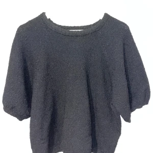 Svart tröja från Lindex - Säljer en svart tröja från Lindex i storlek XL. Jag har vanligtvis S-M i storlek men tyckte denna va finare större. Den är supermjuk och perfekt för både vardag och mysiga kvällar. Tröjan har en enkel design med rund hals och korta ärmar. Den är stickad och har en knottrig struktur, den är i i princip ny! 