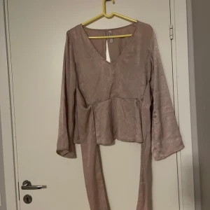 Blus  - Säljer en elegant blus från Chiara Forthi i storlek 36. Klänningen har långa ärmar och ett knytband i midjan för en smickrande passform. Är ganska nopprig men annars hel och fin.