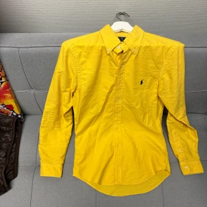 Gul skjorta från Ralph Lauren - Sygg gul skjorta från Ralph Lauren i storlek S. Använd typ 1 gång så den är i nyskick. 