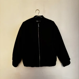 Bomberjacka ifrån Zara - Snygg och varm bomberjacka i teddymaterial ifrån Zara. Sparsamt använd och därmed i mycket bra skick. Passar även XS!