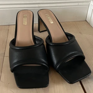 Lägre klackskor med öppen tå - Svarta klackskor med öppen tå och låg klack.