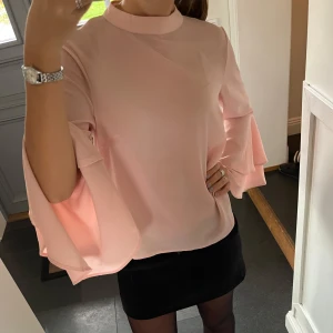 Rosa volangtopp - Rosa blus med volanger från Indiska i storlek M. Fint skick. Använd gärna köp nu!