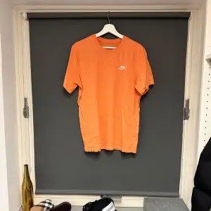 Orange t-shirt från Nike i storlek M. T-shirten är i bomull och har en normal passform. Bra skick. 