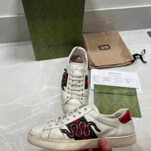 Gucci ace skor - Hej säljer nu mina Gucci ace skor  som är köpta i Melbourne, Australien. Allt OG medföljer. Skick 7/10. Slitna i hälen på skorna men är lagat med lagnings lap. (inget som känns vid förbrukning av skorna) Bara att höra av er vid frågor mvh Viggo! (pris kan diskuteras)