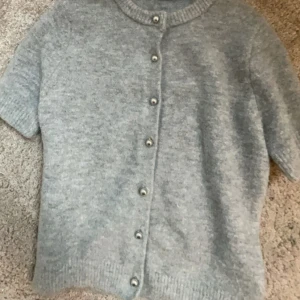 Zara kofta - Jätte fin stickad kortärmad tröja från Zara. Knappt använd men en knapp är påsydd då den satt löst när jag köpte den ( sista bilden) Storlek S i bra skick!💞Nypris: 329 Kr