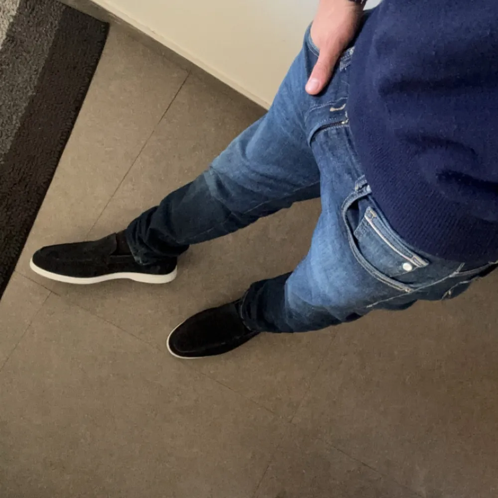 Säljer ett par snygga mörkblå loafers i mocka. De har en stilren design med vit sula som ger en fräsch kontrast. Dessa är storlek 43 men passar på lite större med. Navy blue. Perfekta för både vardag och fest! Skorna är i nyskick och passar perfekt till vilka jeans som helst. Storleken är normal och de är superbekväma att ha på sig. . Skor.