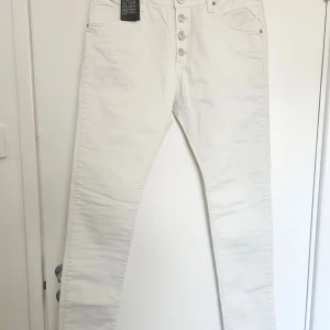 Vita jeansbyxor från Replay - Off white jeansbyxor från Replay med en boyfit passform. Byxorna har en knappgylf och klassiska femficksdetaljer. Perfekta för sommaren.