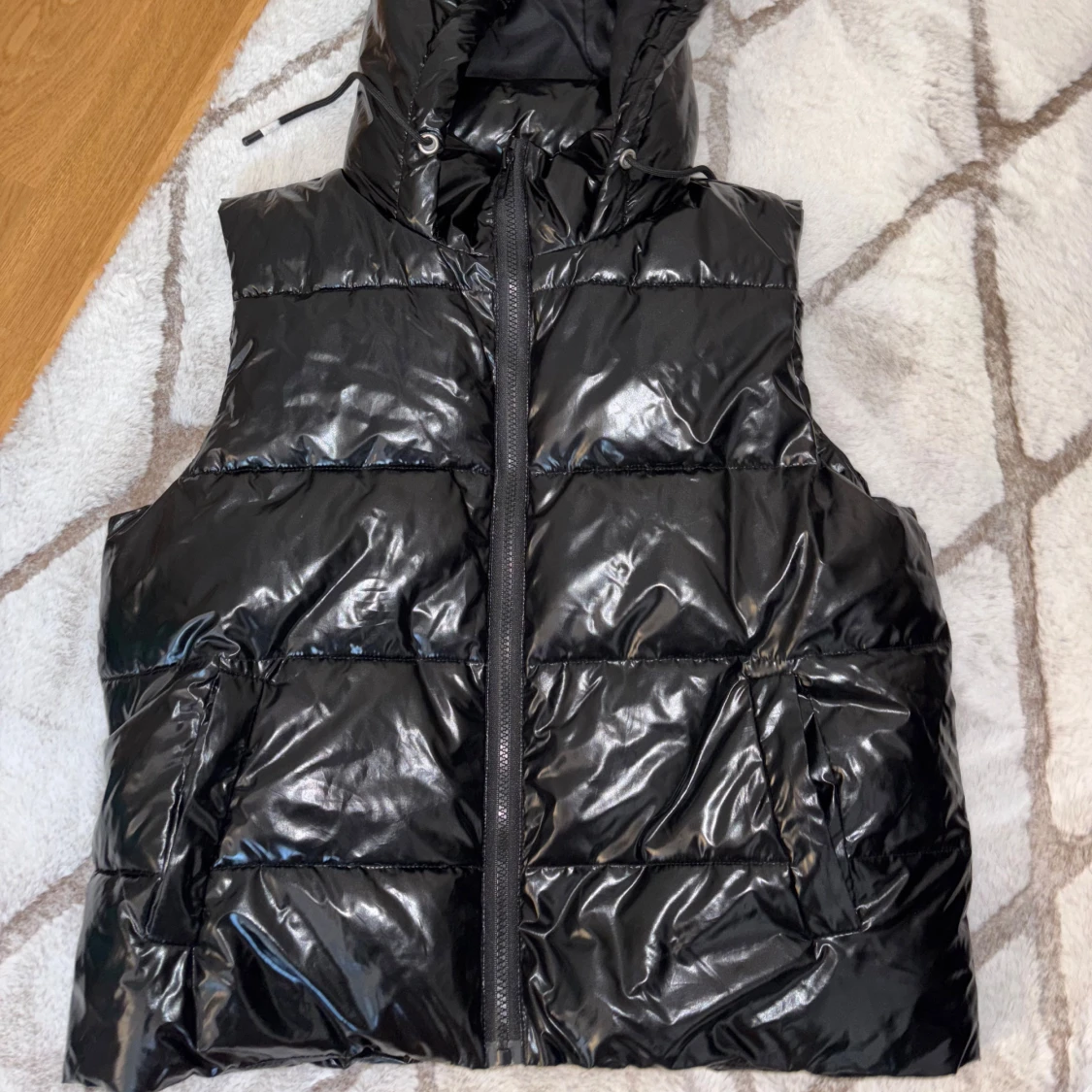 Svart glansig dunväst med huva