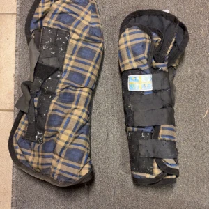Rutig transportskydd - Säljer ett par rutiga hästskydd. De har ett blått och beige rutmönster med svarta detaljer och kardborreband för enkel justering. Perfekt för att skydda hästens ben under transport. Storlek full