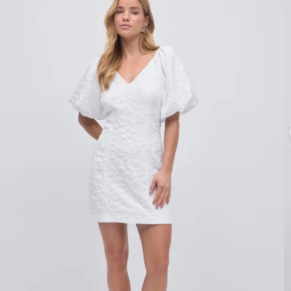 Säljer en elegant vit klänning med puffiga kortärmar och v-ringning. Klänningen har en texturerad yta som ger en unik look. Perfekt för sommarens alla tillfällen! Anledningen till att jag säljer den är för att jag hittade en annan klänning till min student. Denna är super fin och figuraydd.💞(slutsåld, med prislapp och påse) . Mekot.
