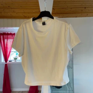 Vit kortärmad t-shirt - Säljer en klassisk vit t-shirt från SHEIN . Den har en rund halsringning och korta ärmar, perfekt för en enkel och stilren look. Passar bra till både jeans och kjol.