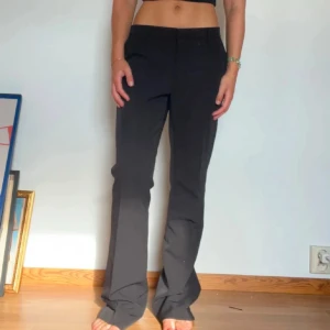 Lågmidjade kostymbyxor från Neo Noir - Snygga svarta lågmidjade kostymbyxor från Neo Noir. Något slitna längst ner då de varit lite långa samt saknas en knapp på insidan, påverkar dock inte funktionen