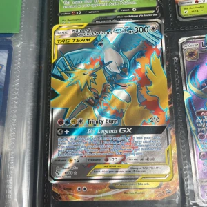 Pokémonkort Moltres, Zapdos & Articuno GX - Säljer ett Pokémonkort med Moltres, Zapdos och Articuno GX i en tag team-version. Kortet har en färgglad design med blå, orange och gul färg. Det är en del av Sky Legends GX-serien och har en hög HP på 300. Perfekt för samlare eller spelare som vill stärka sin kortlek.