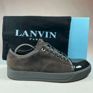 Lanvin captoe - Snygga grå sneakers från Lanvin med en stilren design. Skorna har en kombination av mocka och en glansig svart tåhätta. De har snörning och en robust sula som ger en modern look.