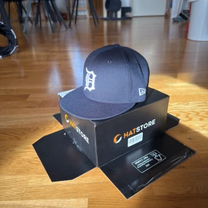 New Era Detroit Fitted Keps - Snygg marinblå keps från New Era, säljer för jag köpte både fel storlek och tog bort klistermärkena så kan ej returnera. Är helt ny och fick inte på den på huvudet så helt oanvänd. Storlek 7 (55,8cm)