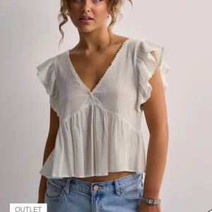 Vit blus med volangärmar från Nelly  - Säljer en söt vit blus från Nelly med volangärmar och v-rigning , upplevdes som xs- s men skulle även passa xxs. Helt oanvänd men utan prislapp. Strykes självklart innan jag postar. Köpt ny för 240. Kontakta vid diskussion av pris eller vid frågor❤️