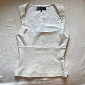 Vit topp från Zara - Jätte fin topp från zara 🫧 Stängs med kedja på sidan. Har två smink sträck vid kedjan (har inte testat att tvätta bort) men det är inget man tänker på 🥰 