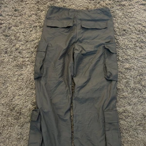 Grå cargopants med fickor - Säljer ett par grå cargopants med flera praktiska fickor. Byxorna har en loose passform 