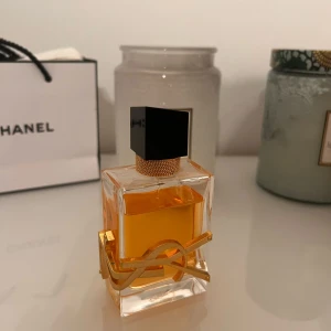 Parfym Bonanza 🥰 Allt givetvis original. Lite billigare vid köp av fler. - Elegant parfymflaska med en geometrisk, guldtonad kork. Flaskan är genomskinlig och innehåller en ljus bärnstensfärgad vätska. Perfekt för den som söker en stilren och modern design.