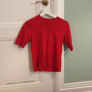 Röd tröja från Lindex - Säljer en röd tröja från Lindex i storlek XS. Tröjan har korta ärmar och en rund halsringning. Perfekt för en färgglad touch i garderoben. Tröjan har en liten fläck där framme!
