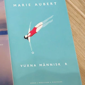 Vuxna människor - Boken 'Vuxna människor' av Marie Aubert har ett turkost omslag med en illustration av en kvinna i röd baddräkt som dyker. Utgiven av Wahlström & Widstrand.