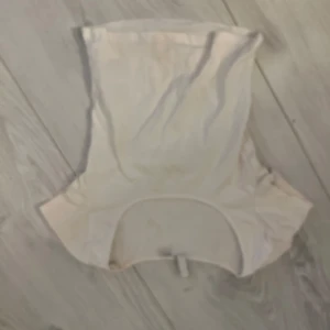 Vit ärmlös topp - Säljer en stilren vit ärmlös topp med rund hals. Perfekt för varma dagar eller som ett basplagg i garderoben.