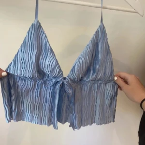 Blå ribbad linnetopp - Snygg blå linnetopp med ribbad textur och smala axelband. Perfekt för varma sommardagar eller som ett lager under en jacka. Toppen har en luftig och bekväm passform.