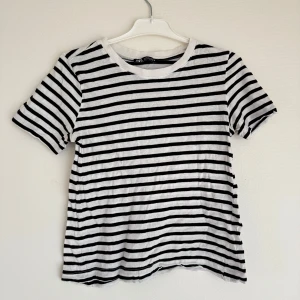 Randig t-shirt från Zara - Säljer en klassisk svartvit randig t-shirt från Zara. Den har korta ärmar och en rund halsringning. 