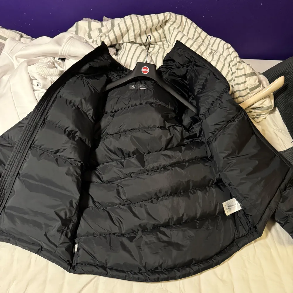 Snygg och varm svart dunjacka från Haglöfs med dragkedja och huva. Perfekt för kyliga dagar med sin pufferdesign som håller värmen. Jackan har en stilren look och är idealisk för både stad och natur.. Takit.