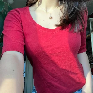 Röd v-ringad topp - Snygg röd topp med v-ringning och korta ärmar. Perfekt för en avslappnad stil. Ger en lite elena Gilbert vibe. Storleken på lappen är M men jag uppfattar den som större. Den är lite sliten, man kan se att den använd alltså men ingen som förstör.