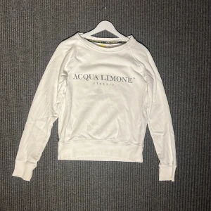 Sweatshirt från Acqua Limone - Säljer en vit tröja från Acqua Limone med deras klassiska logga i svart på framsidan och en stor gul citronhalva på baksidan. Väldigt bra kvalité🥰☀️😍😊originalpris 1000kr