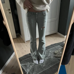 Ljusblå bootcut jeans - Snygga ljusblå bootcut jeans med slitningar på låren och knäna. De är lågmidjade och har en klassisk femficksdesign. Perfekta för en avslappnad stil. Skriv ifall ni vill ha fler bilder💖