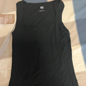 Svart linnetopp från 157 - Snygg svart linnetopp från 157 i mjukt och stretchigt material. Tllverkad av 95% viskos och 5% elastan för en bekväm passform. Fåtal ggr använd. Strl S