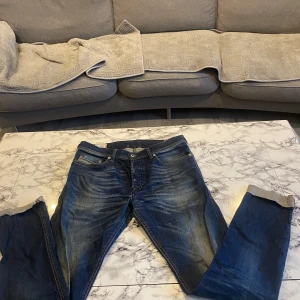 Blå jeans från Diesel - Säljer ett par snygga blå jeans från Diesel. De har en klassisk design med fem fickor och knappgylf. Jeansen har en straight passform och är perfekta för en avslappnad stil. Märket är känt för sin kvalitet och stil.