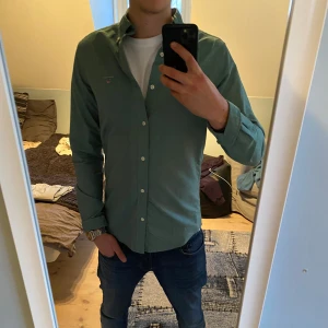 Grön skjorta från GANT - Snygg grön Oxford-skjorta från GANT i slim fit. Tröjan är i storlek small med en unik och snygg färg. Inga defekter. Priset går att diskutera!