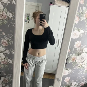 Svart croppad långärmad topp - Snygg svart croppad topp med långa ärmar. Perfekt för en trendig look.