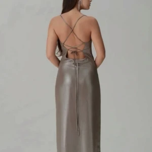 Silverfärgad långklänning från ADOORE - Elegant silverfärgad långklänning med smala axelband och en stilren slits framtill. Klänningen har en öppen rygg med snörning som ger en sofistikerad look. Perfekt för festliga tillfällen🩶Klänningen är endast testad, så prislapp är kvar! Säljer på grund av för stor storlek. Nypris: 1595kr 