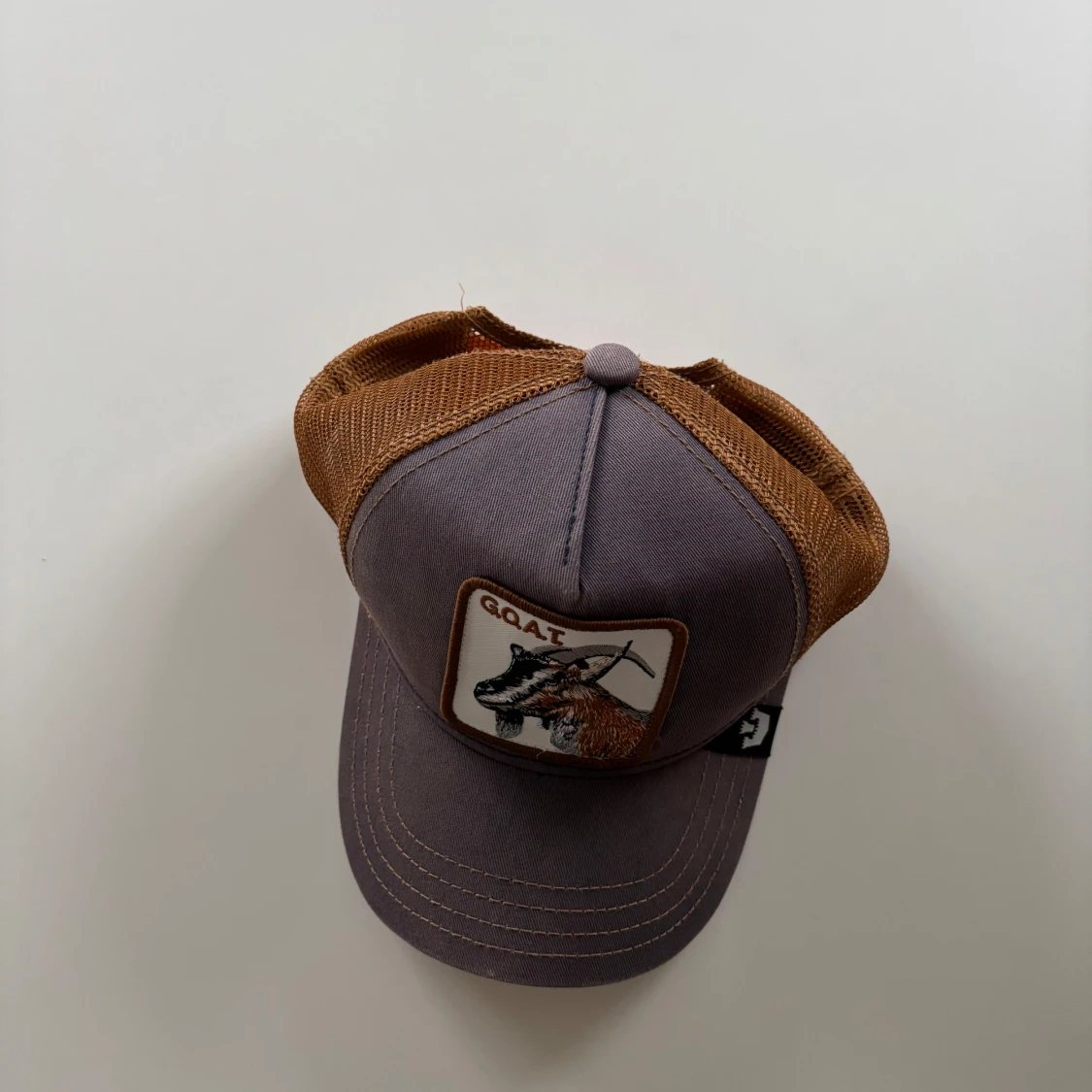 Grå och brun keps med getmotiv