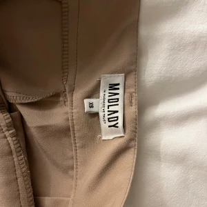 Beige byxor från Madlady - Snygga beige byxor från Madlady i storlek XS. Byxorna har en högmidjad design och en rak passform som ger en stilren look. Perfekta för en chic och avslappnad stil.