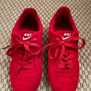 Röda Nike sneakers - Röd cool adidas cortez liknande sneaker. Jättefint skick. Storlek 39. Osäker på äktheten därav priset.