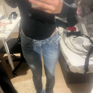 Vintage true religion jeans blåa  - Snygga blå true religion jeans med broderade detaljer på bakfickorna. De har en låg midja och en tight passform fast inte skinny som framhäver figuren. Helt perfekta 