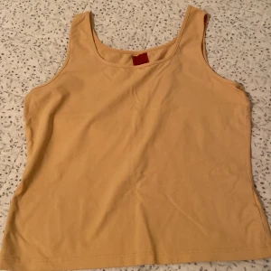  linnetopp från Jacqueline De Yong - Säljer en stilren beige linnetopp från Jacqueline De Yong. Toppen är ärmlös och har en klassisk rund halsringning. .